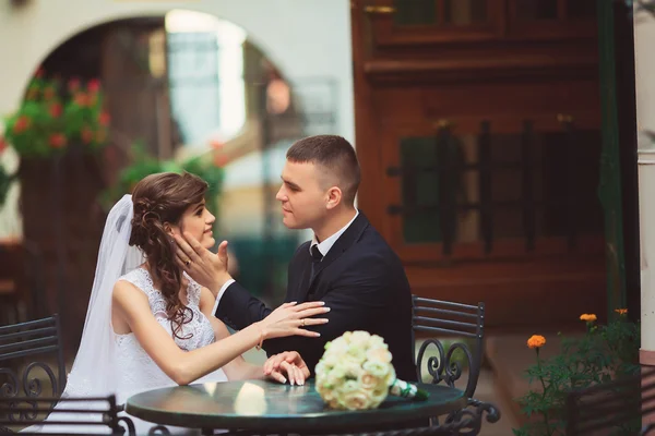 Νύφη και γαμπρός σε μια υπαίθρια καφετέρια αρραβωνιαστικός κατέχει πρόσωπο νύφη — Φωτογραφία Αρχείου