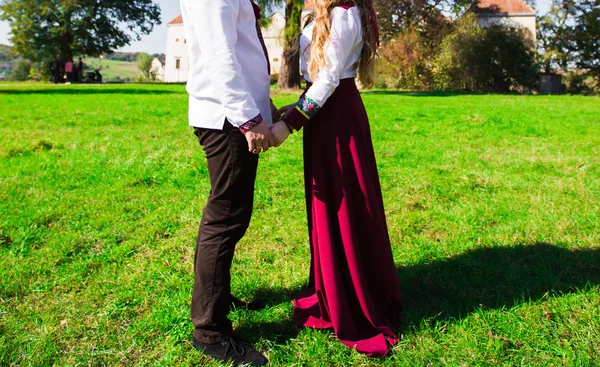 Verliebtes junges Paar geht Händchen haltend durch den Herbstpark — Stockfoto
