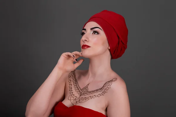 Красивая девушка с красным шарфом, серый фон изолирован — стоковое фото