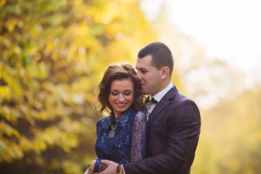 Wedding couple in autumn park, tenderness and love