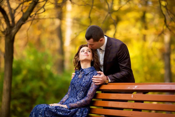Счастливая невеста, жених держится за руки в желтом парке, целуется, улыбается — стоковое фото