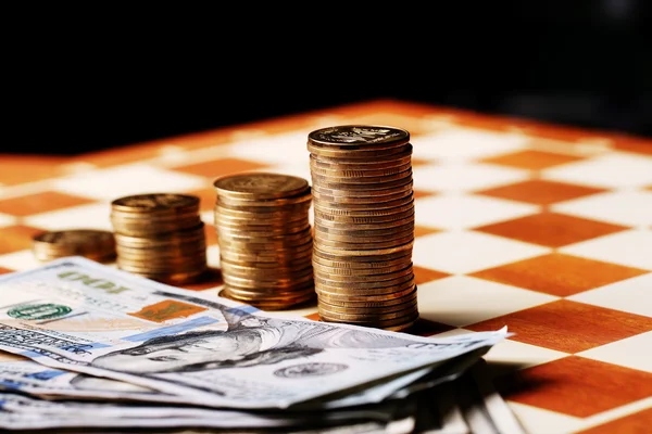 Tower mynt och dollar på ett schackbräde, pengar — Stockfoto