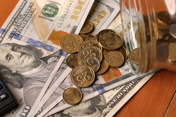 Burk med pengar fallande mynt för dollar, kalkylator på baksidan — Stockfoto