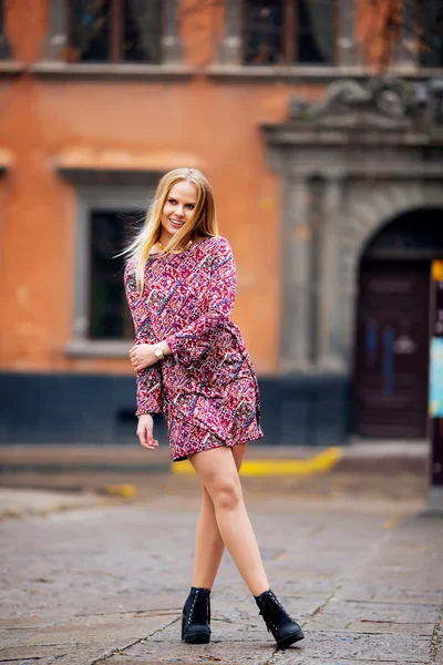 Beautiful woman on the background of houses smiling — Stock Photo, Image