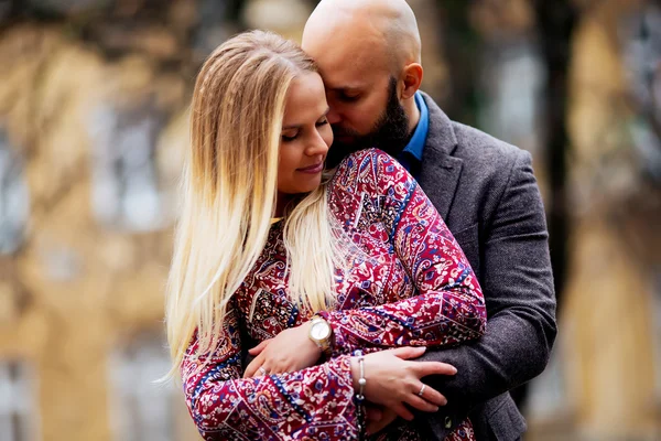 Ungt par i kärlek, kramar på gatan. Selektiv inriktning. skallig kille med skägg — Stockfoto