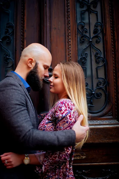Couple heureux taille basse étreignant et souriant, embrassant sur le fond de vieux bâtiment — Photo