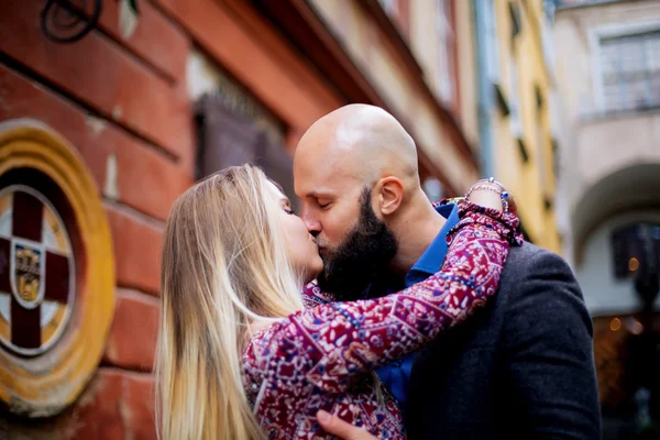 Happy couple low waist hugging and smiling, kissing on the background of old building — Stock Photo, Image