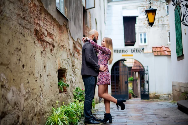 Young fashion elegant stylish couple posing on streets of european city in summer evening weather. Sensual blonde vogue girl with handsome hipster man having fun outdoor.