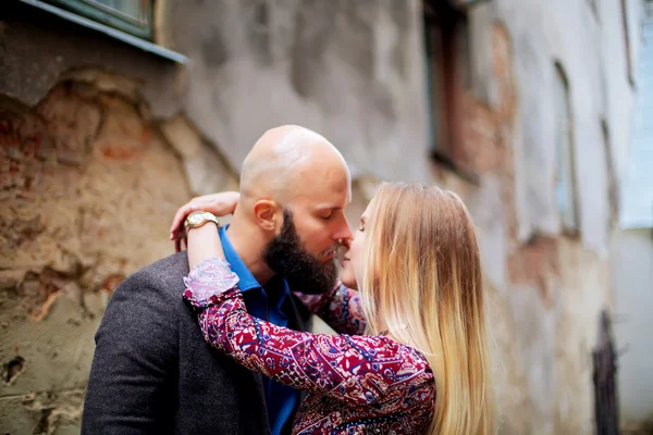 Happy couple low waist hugging and smiling, kissing on the background of old building — Stock Photo, Image
