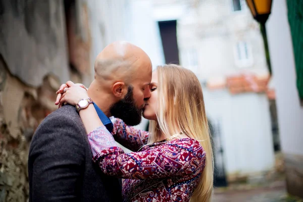 Щаслива пара низька талія обіймається і посміхається, цілується на тлі старої будівлі — стокове фото