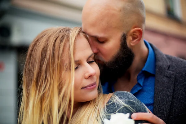 En bild av ett par glada på alla hjärtans dag med blommor, kysser henne — Stockfoto