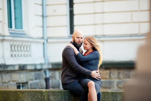 Um belo casal emocional elegante de mulher jovem e homem sênior com longa barba preta abraçando sentado perto um do outro — Fotografia de Stock