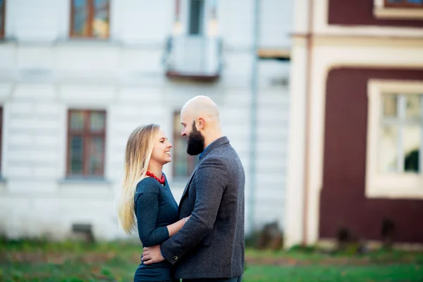 Portrait of happy couple hugging in the city and standing face to face. Beautiful people in love. — Stock Photo, Image