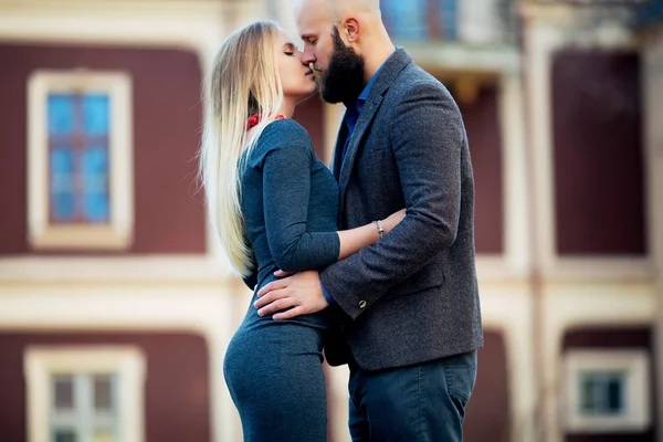 Couple heureux taille basse étreignant et souriant, embrassant sur le fond de l'ancien bâtiment, un couple élégant — Photo