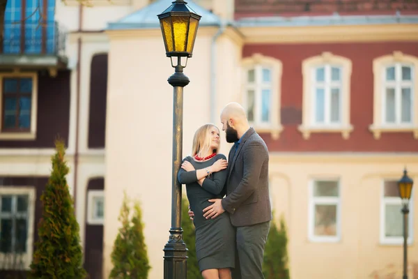 Vacker flicka omfamnar den killen, stilfullt klädd, skallig man med ett skägg — Stockfoto