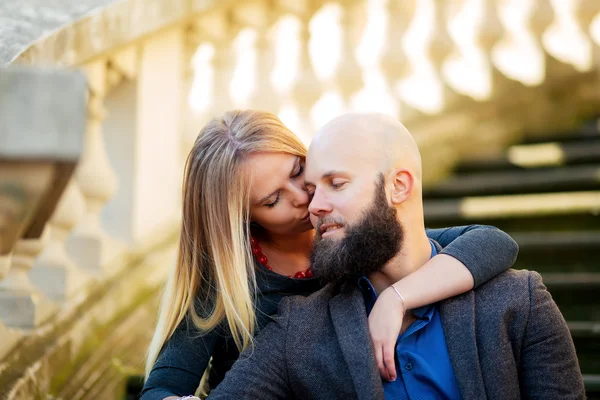 Jeune couple, élégamment habillé, assis sur les marches, contre un bâtiment historique — Photo