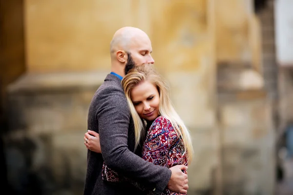 Pareja joven enamorada, abrazándose en la calle. Enfoque selectivo. calvo con barba —  Fotos de Stock