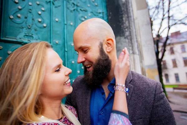 Casal jovem apaixonado, abraçando na rua. Foco seletivo. careca com barba — Fotografia de Stock