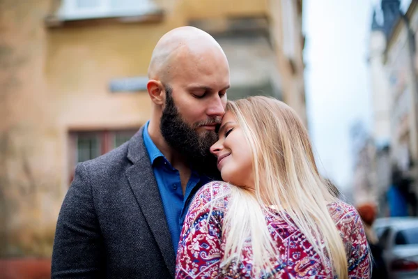 Ungt par i kärlek, kramar på gatan. Selektiv inriktning. skallig kille med skägg — Stockfoto