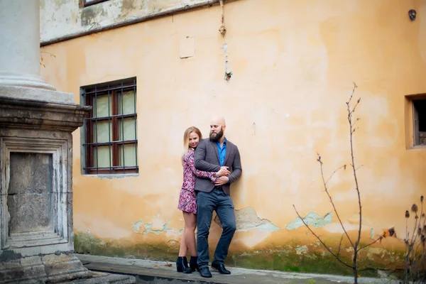 Romantisches Brautpaar, das sich Händchen hält und küsst, mit einem Denkmal im Hintergrund — Stockfoto