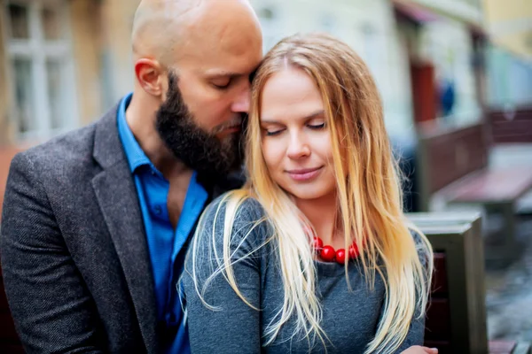 Pareja joven enamorada, abrazándose en la calle. Enfoque selectivo. calvo con barba —  Fotos de Stock