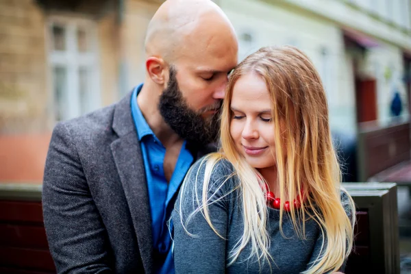 Casal feliz no amor uns com os outros, Um belo casal elegante de mulher jovem e homem sênior com longa barba preta abraçando perto uns dos outros ao ar livre na rua de outono em escadas dia ensolarado — Fotografia de Stock