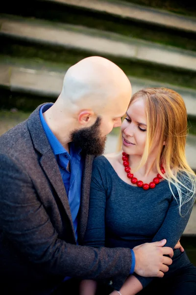 Happy couple smiling, standing near the wall in the arms — Stock Photo, Image