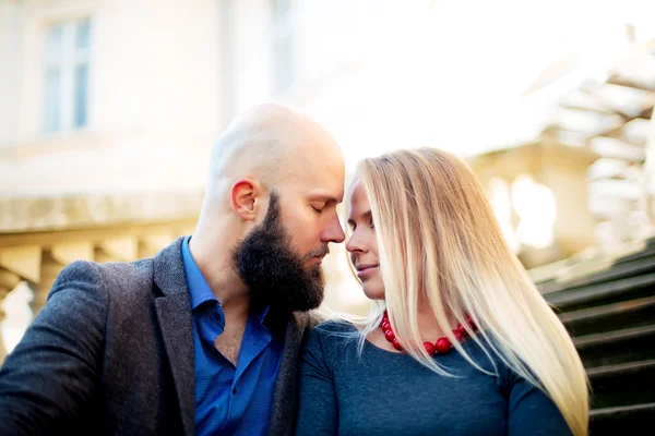 Casal feliz no amor uns com os outros, Um belo casal elegante de mulher jovem e homem sênior com longa barba preta abraçando perto uns dos outros ao ar livre na rua de outono em escadas dia ensolarado — Fotografia de Stock