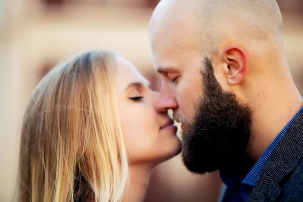 Gelukkige paar verliefd op elkaar, een mooie stijlvolle paar jonge vrouw en senior man met lange zwarte baard omarmen dicht bij elkaar in het najaar straat op trap zonnige dag buiten — Stockfoto