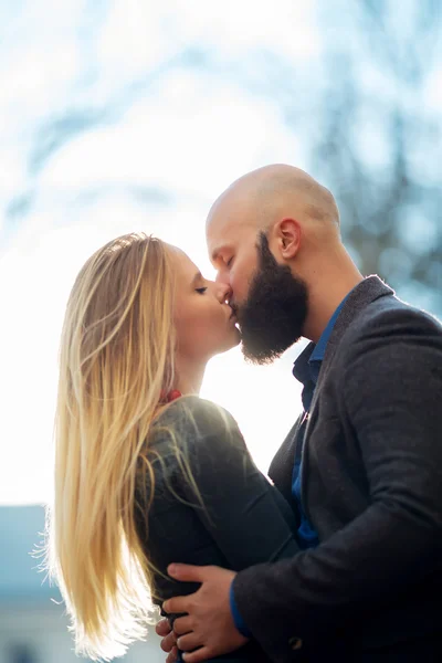 Happy couple in love with each other,One beautiful stylish couple of young woman and senior man with long black beard   embracing close to each other outdoor in autumn street on stairs sunny day — Stockfoto