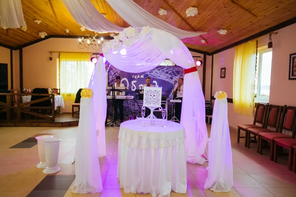 A beautiful wedding arch suite, decorated with flowers, amid the beautiful banquet hall