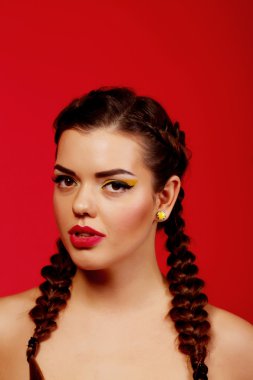 Güzel şehvet, zarif esmer kadın, kahverengi gözlü, kıvırcık saçlı, seksi gülümseyen dudaklı. Stüdyo portresi. Doğa romantizmi saf makyaj. Kırmızı arka plan. Güzellik saç stili.