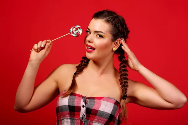 Young woman with heart shaped pink lollipop — Stock Photo, Image