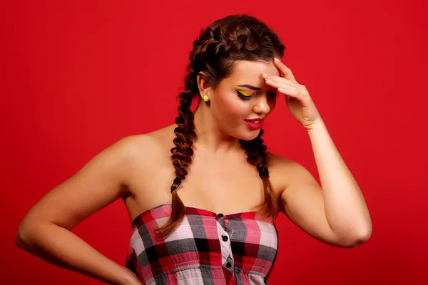 Ritratto emotivo di una bella ragazza rossa (zenzero) con i capelli volanti. Ragazza con trucco e abito da sera cocktail posa in viola (rosso) sfondo. studio girato — Foto Stock