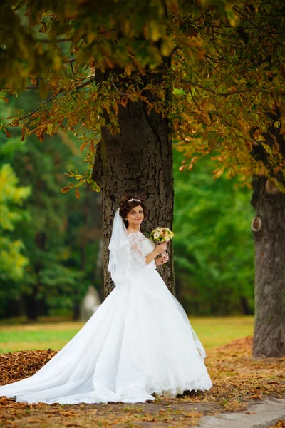 Prachtige stijlvolle blonde bruid in vintage witte jurk wandelen in het park — Stockfoto