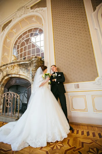 Glückliche Braut und Bräutigam schauen sich im Hochzeitspalast an — Stockfoto