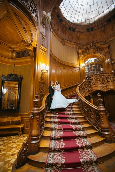 Büyük ahşap merdivenleri olan eski bir evde ve sarayda zarif bir çift. — Stok fotoğraf