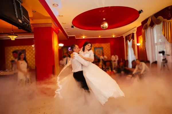 Bruid en bruidegom dansen op de eigen bruiloft met witte rook — Stockfoto
