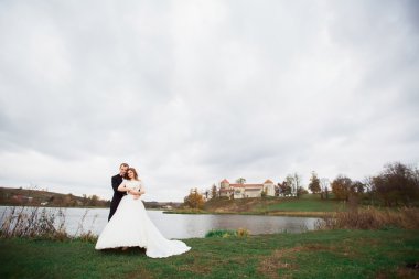 aşık çift açık havada Orman ağacı mavi göle sarılmak