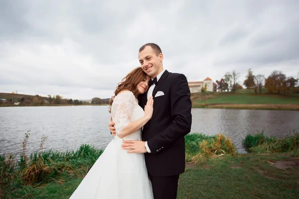 Gelin ve damat dışarıda ağaçların altına park ediyorlar. — Stok fotoğraf