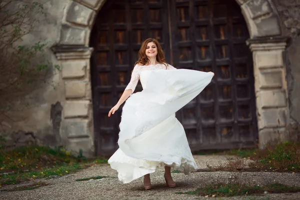 Красивая женщина в белом свадебном платье танцует — стоковое фото