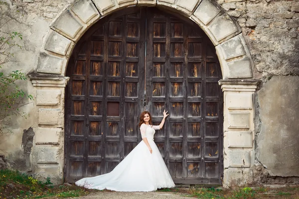 Elegant stilvolle süße junge schöne Braut in erstaunlichem Brautkleid steht auf dem alten Palast — Stockfoto