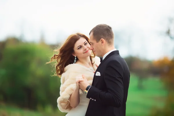 Casal bonito novo da mulher no vestido longo branco e no véu e no homem no terno formal preto que está junto na floresta verde profunda no fundo natural, quadro horizontal — Fotografia de Stock