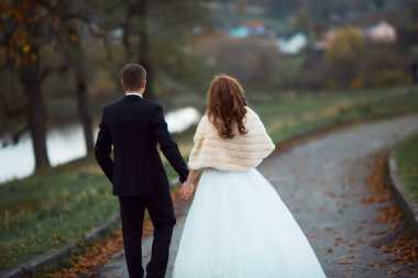 gün batımı, gelin ve damat, Bahçe zemin karşı elinde iki sonra düğün kıyafetleri ile bir buket çiçek ve yeşillik olduğunu