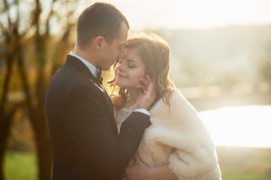 Gelin ve damat gün açık havada bahar doğada yürüyüş düğününde. Gelin çift, mutlu yeni evli kadın ve erkek sonbahar parkta kucaklayan. Sevgi dolu evlilik çift açık. Gelin ve damat