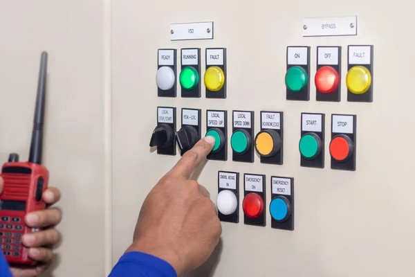 Hand of people key switch select mode in electrical control panel contains switch buttons for operating industrial machine and factory equipment in industr