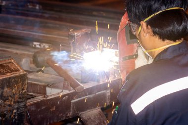 Çelik kaynakçılığı yapan adam, erkek işçi metali PPE güvenlikli fabrikada çalışıyor.