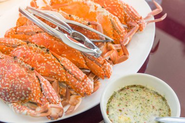 Taze ızgara yengeç ve Tayland usulü deniz ürünleri sosu servis edilmeye hazır.