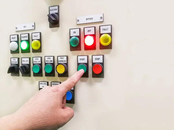 Hand holding the control panel of the industrial plant and pushing or turning the button in electrical selector switch,button switch motor control center cabine