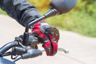 Motosikletli bir adam eldivenli, motorsiklet gaz kontrolü ve güvenlik için önemli bir koruyucu giysidir.